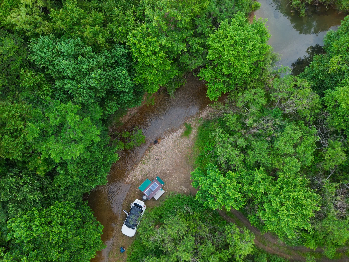 Aerial view of a mobile field camp beside a stream